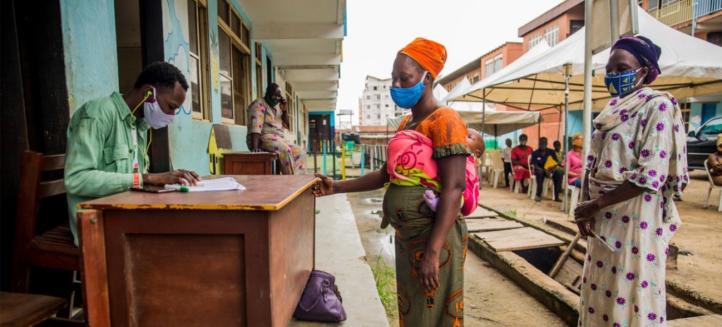 ONU-Mujeres nigerianas toman vales de alimentos como parte de un programa de apoyo a las familias que luchan contra el confinamiento de la COVID-19